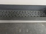 two metal trays with holes on them sitting on a white surface
