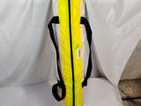 a yellow surfboard bag sitting on top of a white sheet
