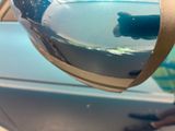 a fish in a bowl that is being held up by a pair of scissors