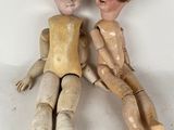 two wooden dolls sitting next to each other on a table