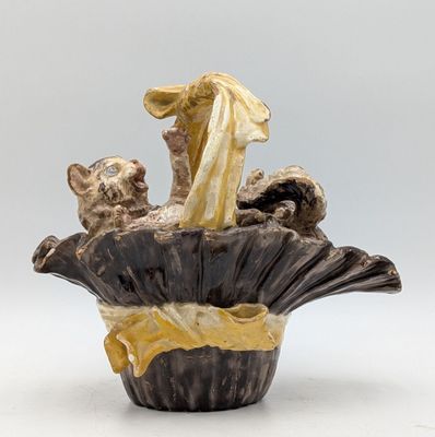 a vase with a figurine of a woman and a cat in it