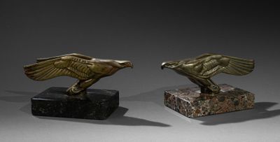 une paire d'aigles en bronze sur des socles en marbre, sur fond gris