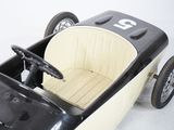 a black and white pedal car with a steering wheel