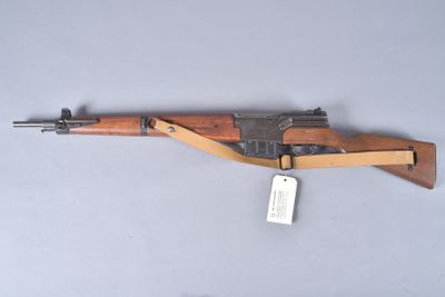 an old wooden rifle with a tag attached to it ' s side