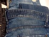 two pairs of jeans are sitting next to each other on a white surface