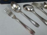 five spoons and two forks on a table