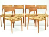 four wooden chairs with woven seats on a white background