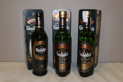 trois bouteilles de bière sont posées sur une table à côté d'une boîte