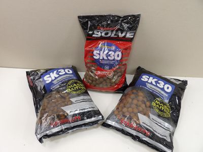 trois sacs d'aliments pour poissons SK20 posés sur un comptoir
