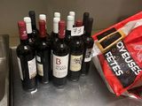 plusieurs bouteilles de vin posées sur le comptoir, à côté d'un paquet de chips