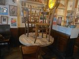 a table and chairs in a room with pictures on the walls