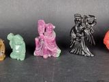 six small figurines of different colors and sizes on a black surface