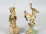 deux figurines représentant un homme et une femme tenant un oiseau dans leurs mains