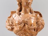 carved bust of a woman in a dress on a clear base