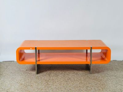 une table basse orange posée sur un sol recouvert de moquette