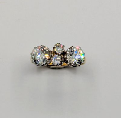 a three stone diamond ring on a white surface