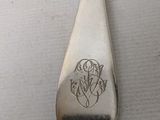 a silver spoon with a design on it sitting on a table