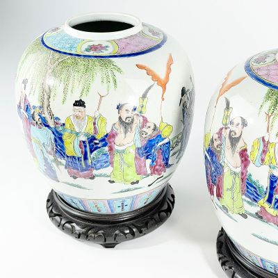 paire de vases orientaux ornés de personnages peints, posés sur un socle