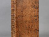 an old book sitting on top of a table next to a gray background