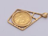 a close up of a gold coin in a square pendant on a white surface
