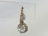 a close up of a diamond pendant on a clear surface
