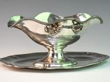a silver plate with a bowl on it on a table