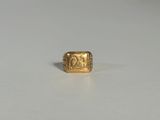 un gros plan d'une bague en or sur laquelle figure l'image d'un homme