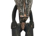l'image d'une statue en bois représentant un homme avec un chapeau sur la tête