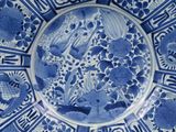a blue and white plate with birds and flowers on it
