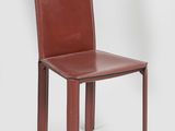 the back of a brown leather dining chair with a wooden frame