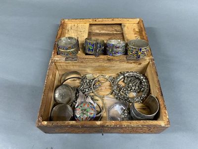 a wooden box filled with assorted silver items