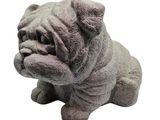 une statue représentant un chien assis sur une surface blanche