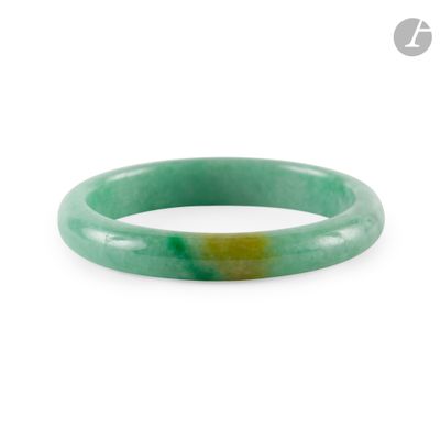 un gros plan d'un bracelet en jade vert sur fond blanc