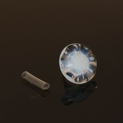 un gros plan d'un objet en verre posé sur une table, avec un morceau de plastique