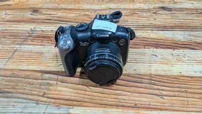 a camera sitting on a wooden table with a tag attached to it