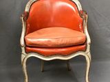 une chaise orange et blanche avec une assise en cuir sur fond gris