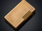 a gold cigarette case sitting on top of a black surface