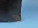 an old black leather purse with a metal clasp on a blue background