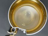 a cup and saucer on a table with a spoon in it