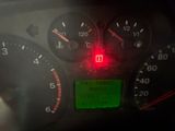 a close up of a car dashboard with a red light