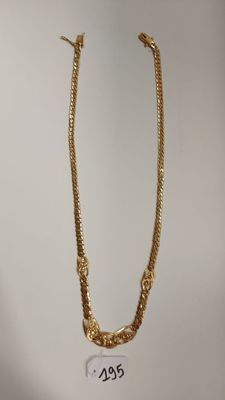 un collier plaqué or avec une chaîne sur fond blanc