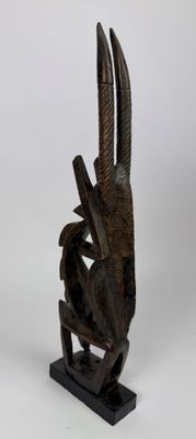 une image d'une sculpture en bois représentant un oiseau sur un support
