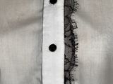 a close up of a white shirt with a black lace trim
