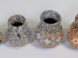 four vases sitting next to each other on a table