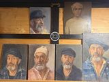 tableau représentant un groupe de vieillards coiffés de chapeaux et barbus, posé sur une étagère