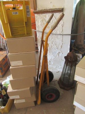 des cartons empilés les uns sur les autres à côté d'un diable