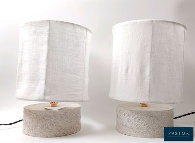 une paire de lampes de table en béton avec des abat-jours en lin blanc