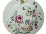 une assiette ornée de fleurs et d'oiseaux sur fond blanc