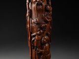 une figurine en bois sculptée représentant un homme barbu muni d'un bâton