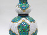 un vase bleu et blanc posé sur une table sur laquelle se trouve une lampe